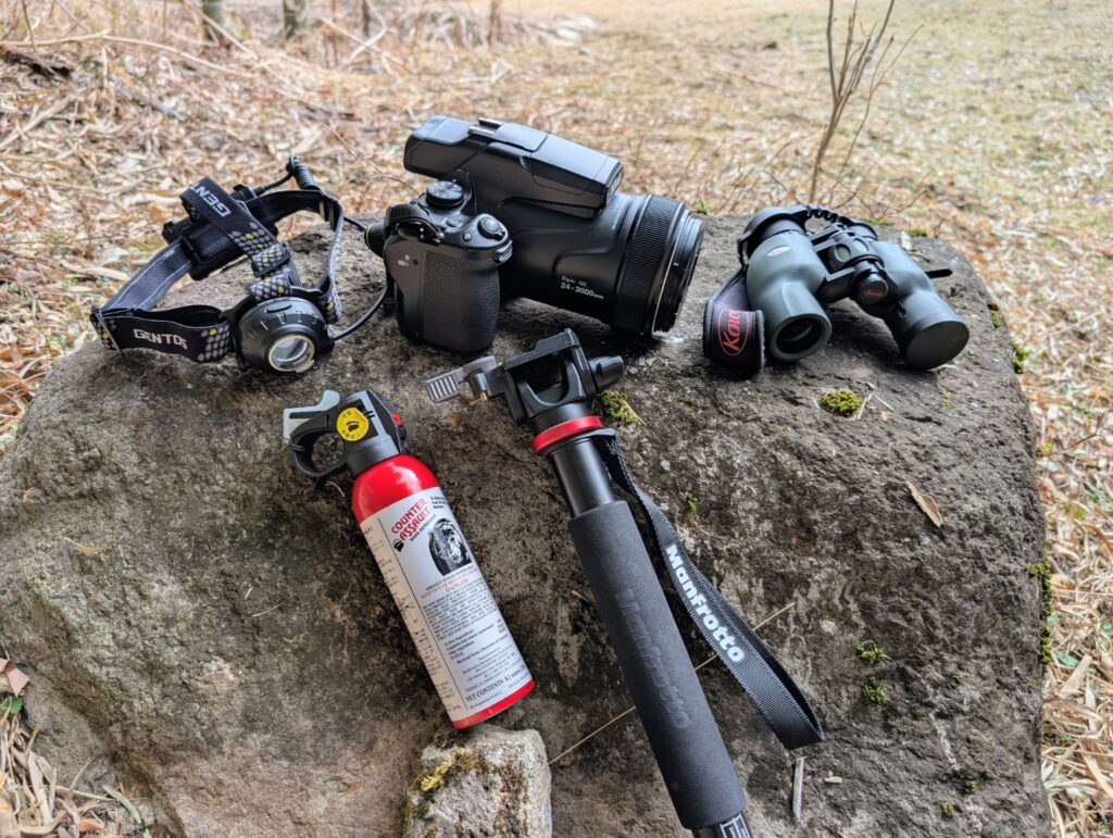 野生動物観察に使用している装備一式（双眼鏡・超望遠カメラ・熊スプレー・ヘッドライト）